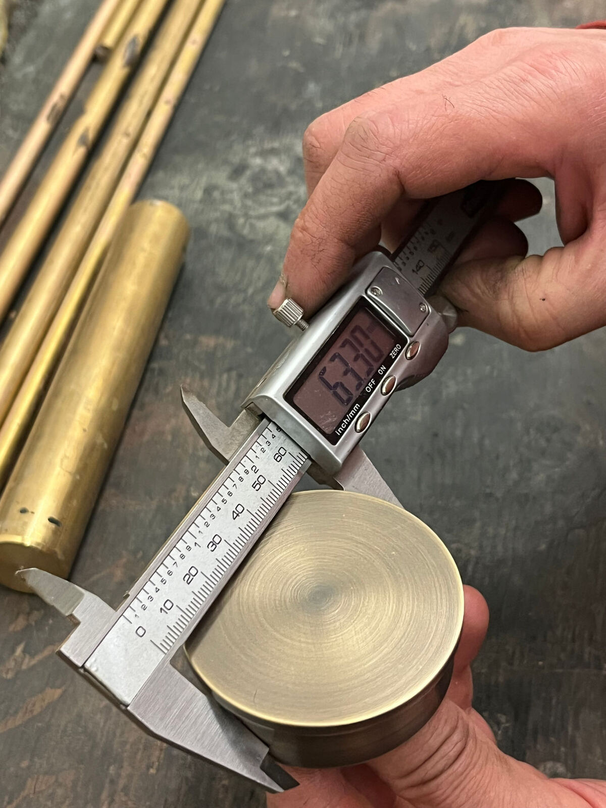 Measuring a finial with callipers in the workshop